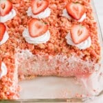 Strawberry Crunch Poke Cake in a baking dish with a piece missing