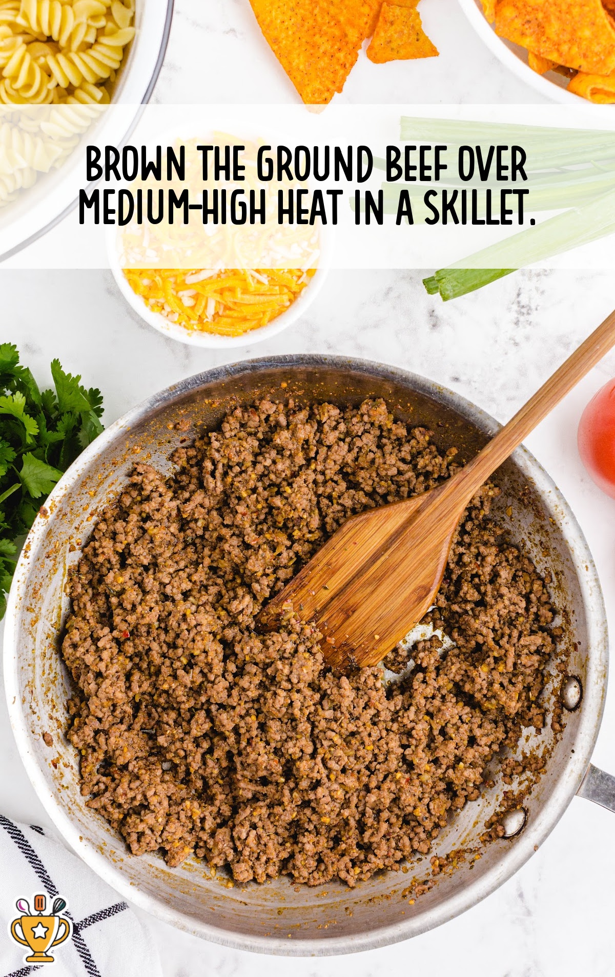 ground beef in a skillet with a wooden spoon