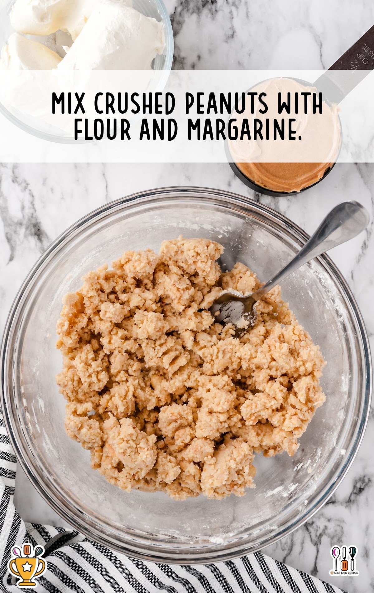 crushed peanuts with flour and margarine in a bowl with a spoon in it