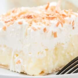 a piece of No Bake Coconut Cream Bars on a white plate