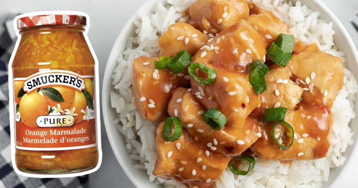 Crockpot Orange Chicken served wit rice in a bowl, and a jar of orange marmalade on the side