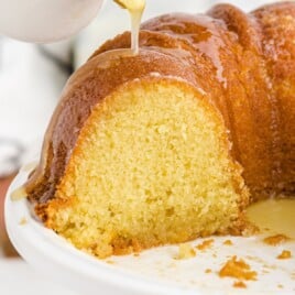 pouring sauce over the Kentucky Butter Cake on a plate
