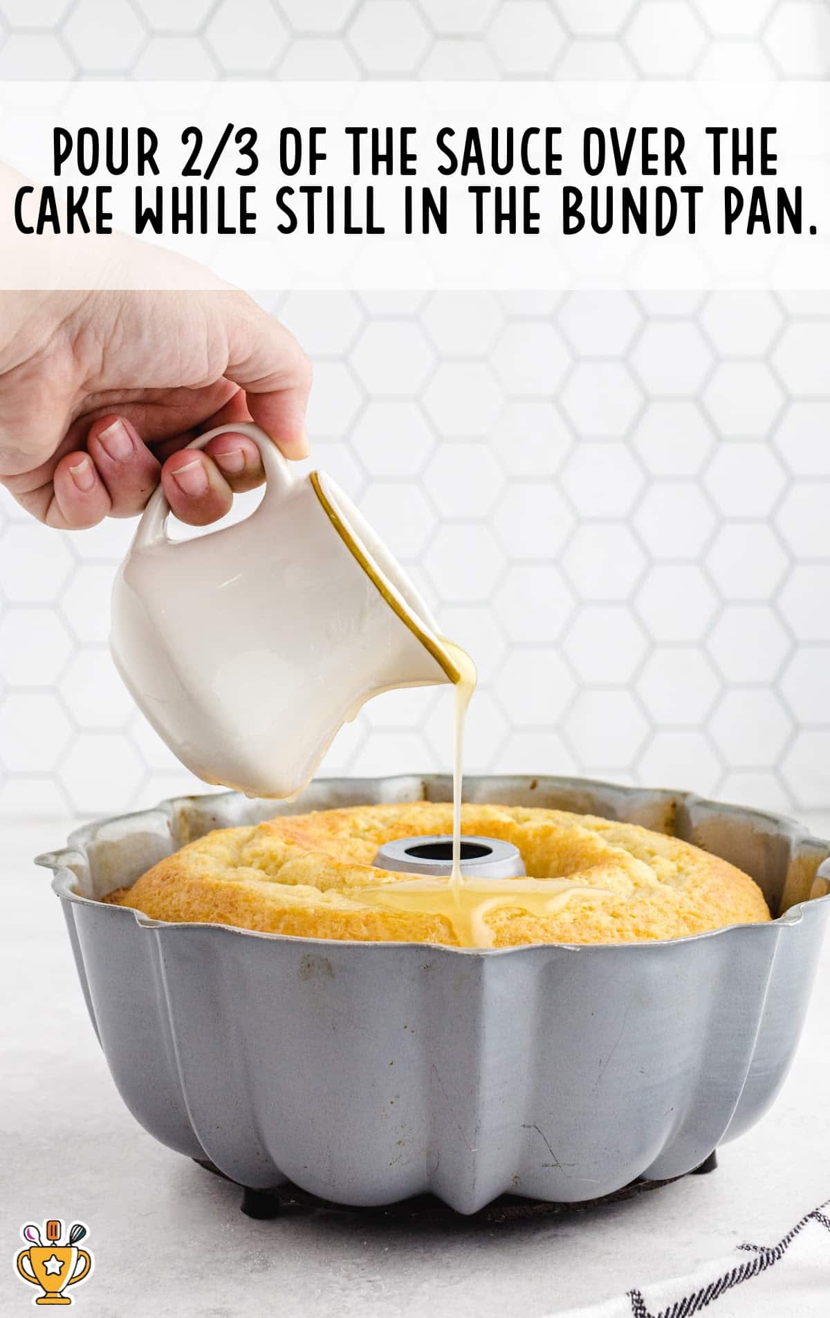a hand pouring sauce over the Kentucky Butter Cake in a bundt pan