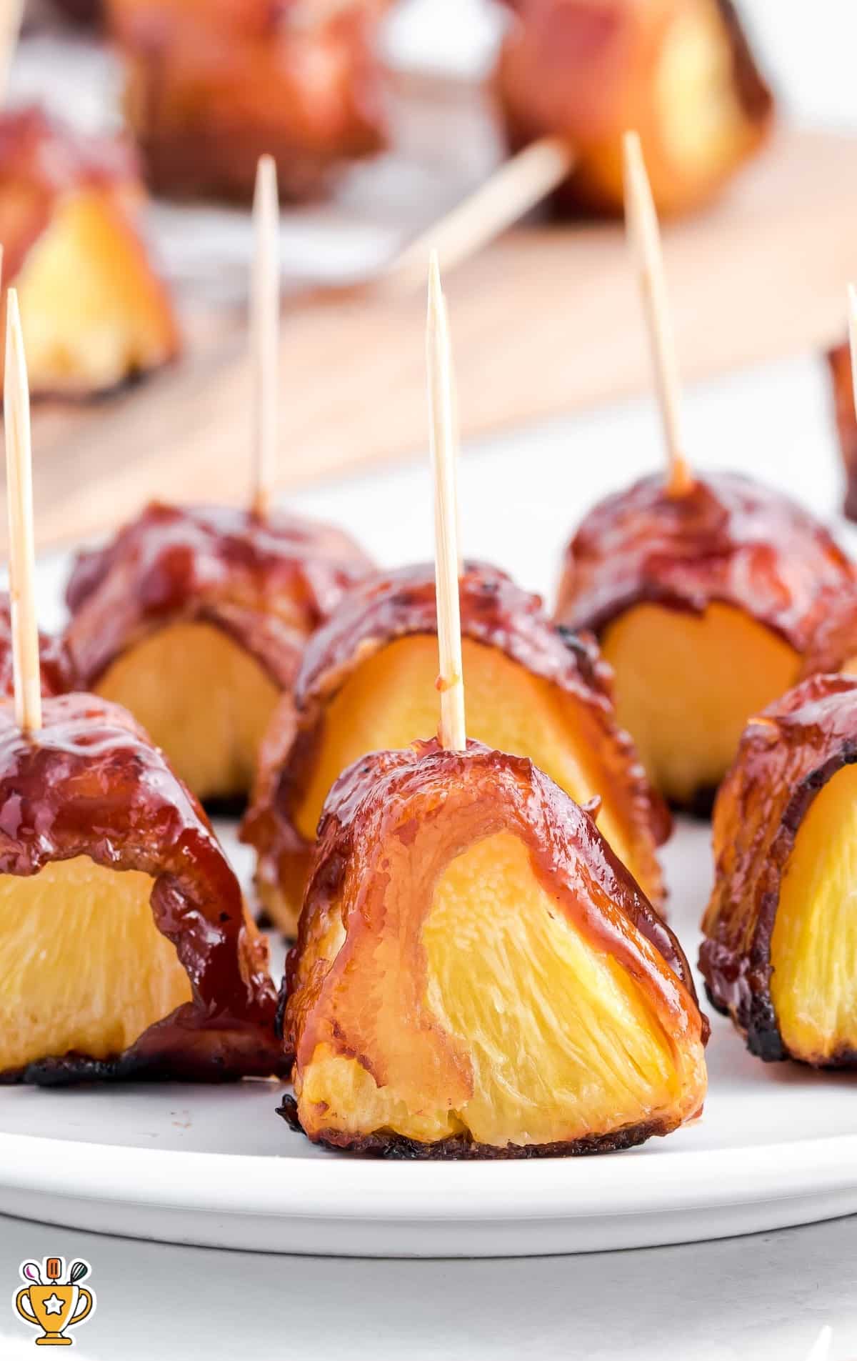 Bacon Wrapped Pineapple pieces on a white plate