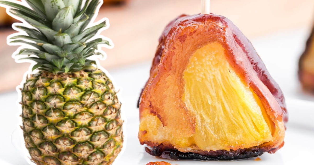 a piece of Bacon Wrapped Pineapple and a whole pineapple on the side