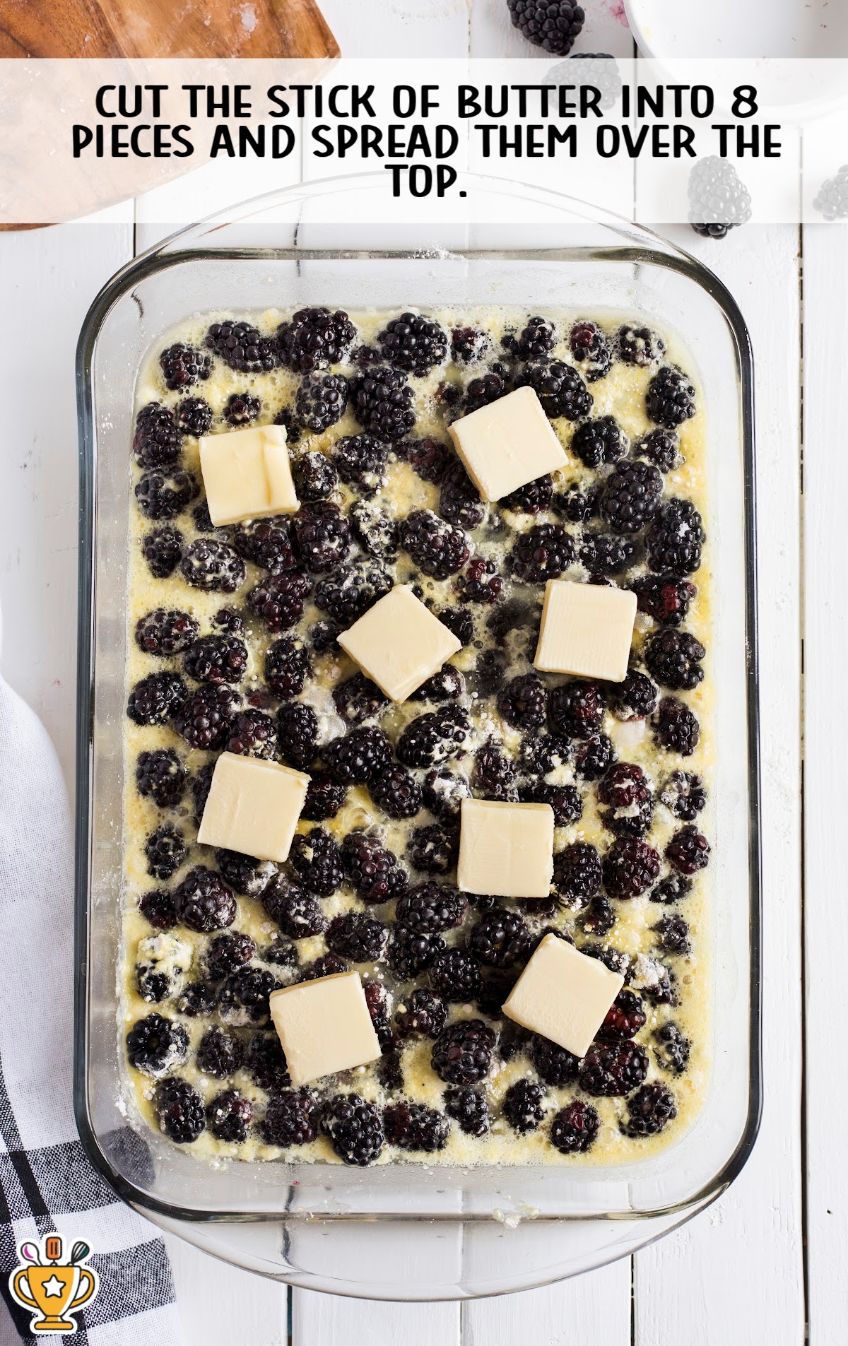 Slices of butter placed on top of blackberry and cake mixture before baking