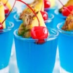 A close up of shot glasses full of Blue Hawaiian Jello Shots.