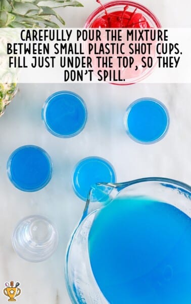 Blue Hawaiian Jello Shot mix is poured into shot glasses.