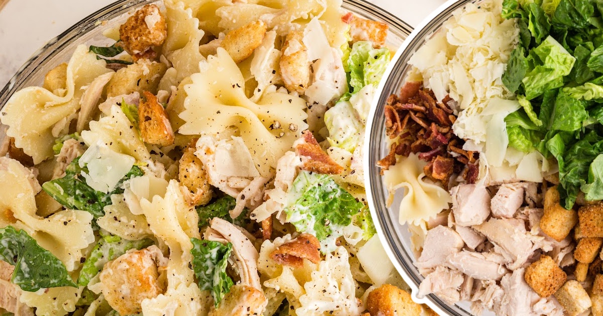 Close-up of a large bowl filled with creamy Caesar pasta salad made with bowtie pasta, lettuce, croutons, and shaved parmesan.