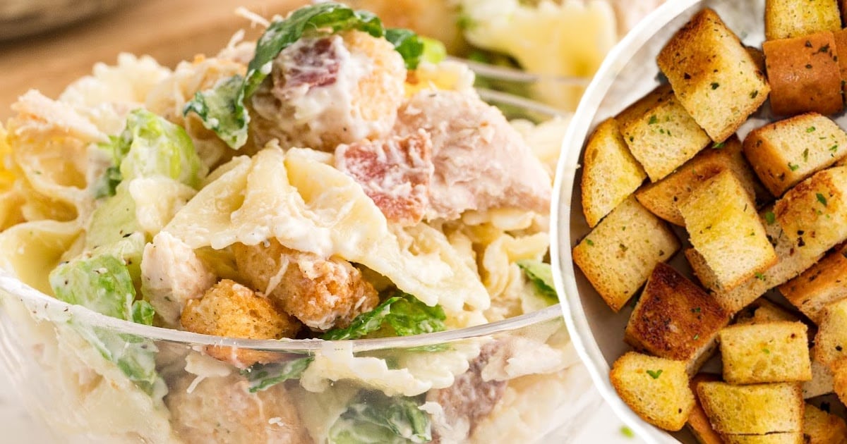 Barilla Farfalle pasta box beside a bowl of Caesar pasta salad with romaine, croutons, shredded chicken, and creamy dressing.