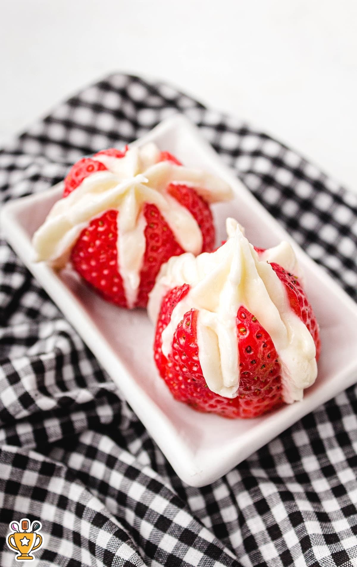 two Cheesecake Stuffed Strawberries on a plate