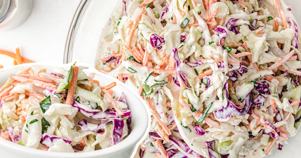 A bright, detailed image of coleslaw in a bowl, highlighting the fresh mix of green cabbage, red cabbage, and orange carrots.