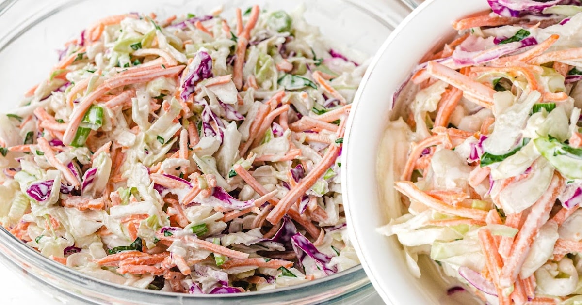 A close, angled view of creamy coleslaw, showing the texture of the dressing and the variety of crunchy vegetables.