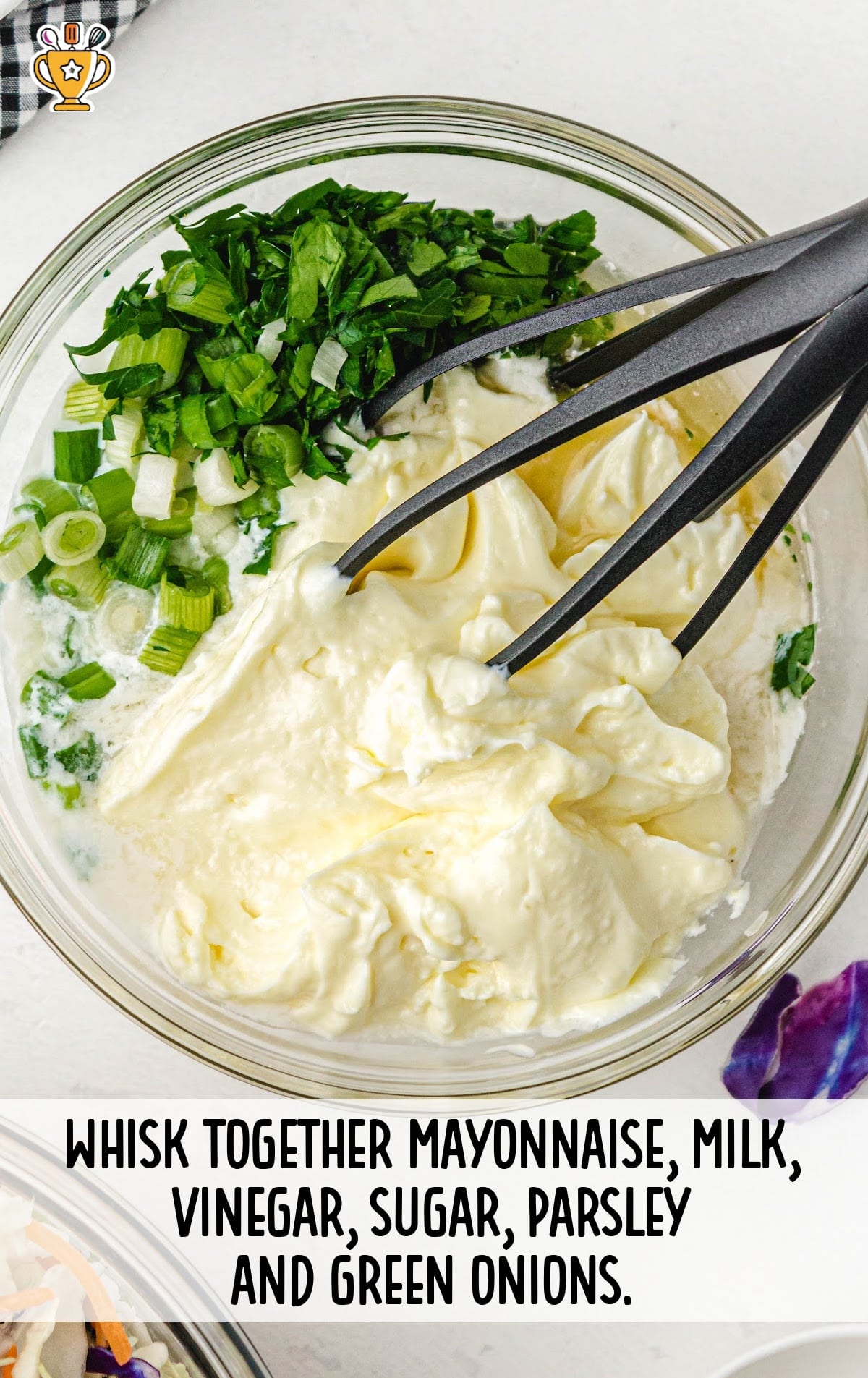 A bowl of mayonnaise, milk, vinegar, sugar, chopped parsley, and green onions ready to be whisked into a creamy dressing.
