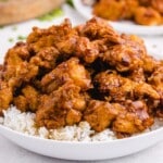 Bowl of golden fried honey chicken glazed with sauce and served over fluffy white rice.