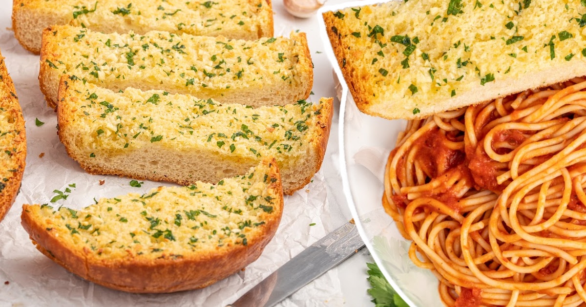 pieces of Garlic Bread with some noodles on the side