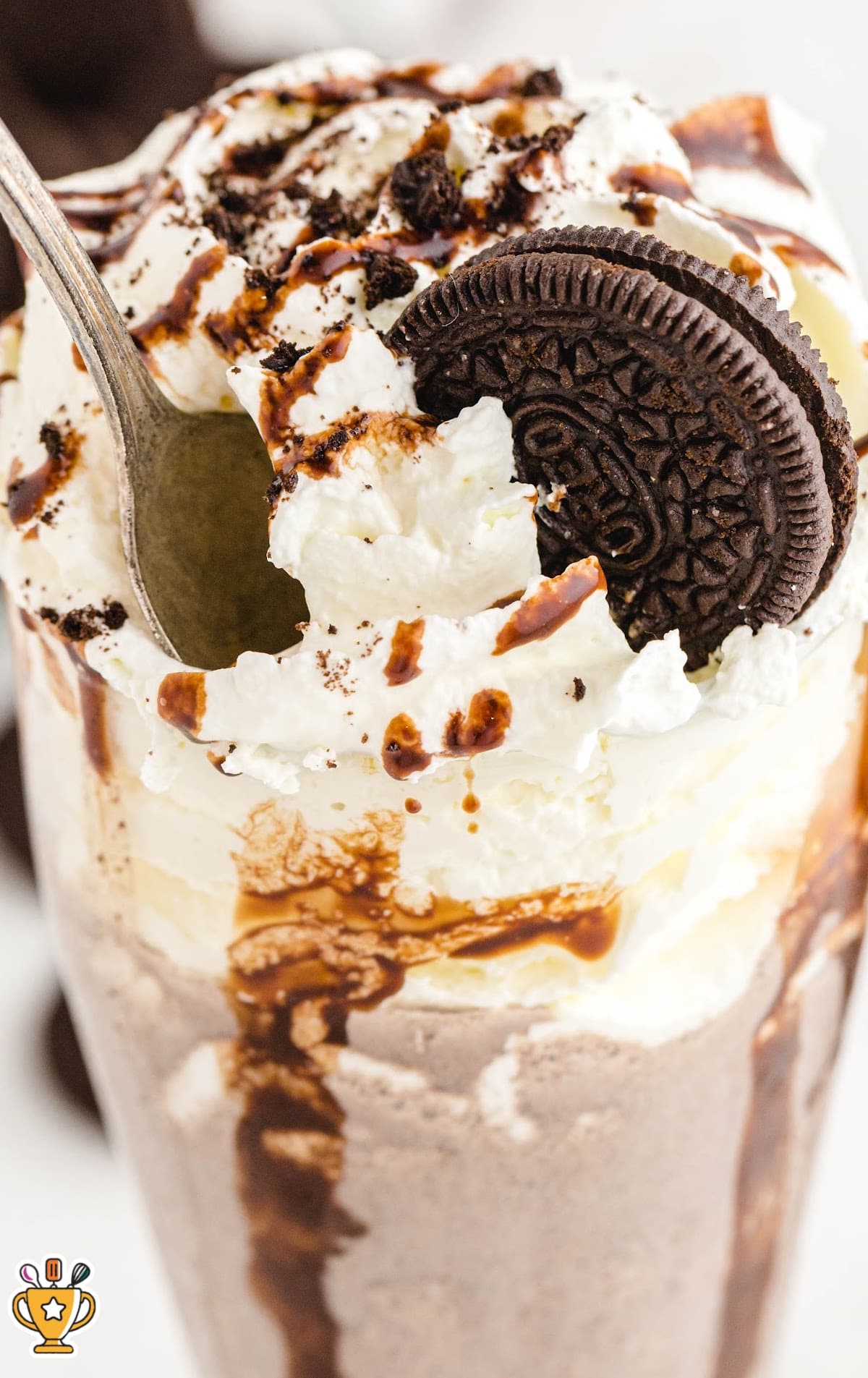 Oreo Milkshake in a glass with a spoon in it