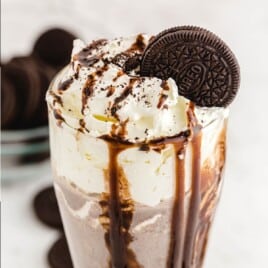 a glass full of Oreo Milkshake with an oreo cookie in it