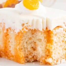 a piece of Orange Creamsicle Poke Cake on a plate