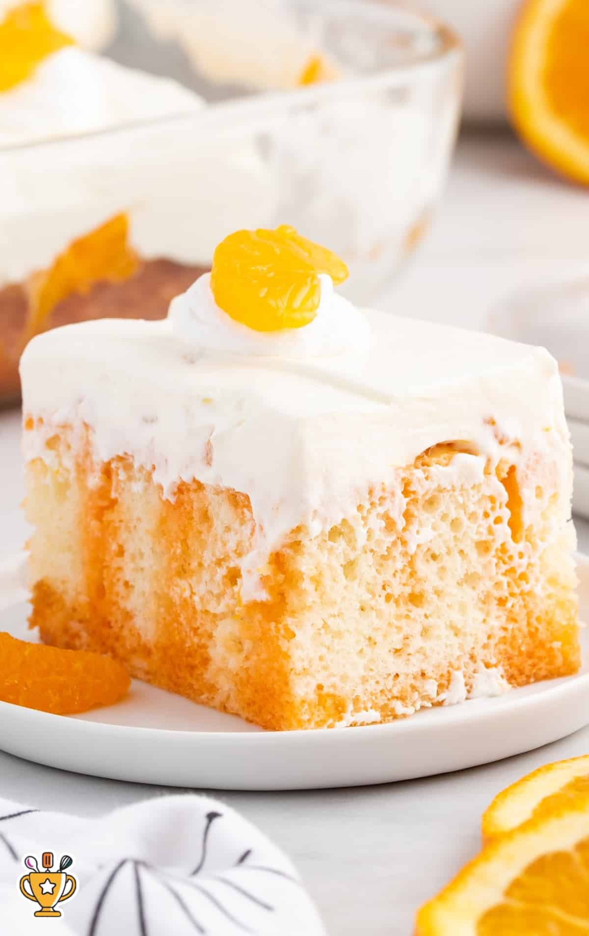 a piece of Orange Creamsicle Poke Cake on a plate
