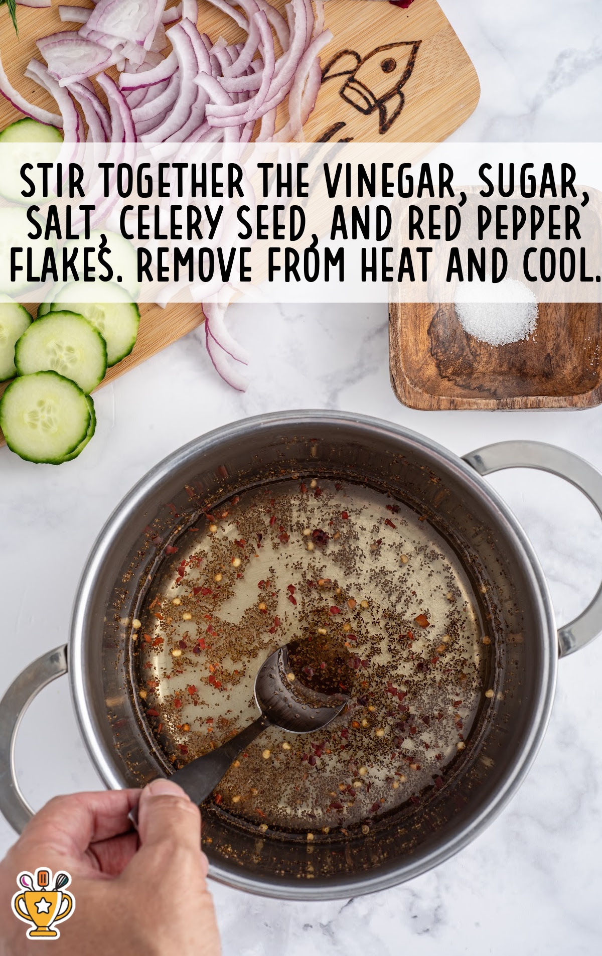 Vinegar, sugar, salt, celery seed, and red pepper flakes in a saucepan being stirred with a spoon