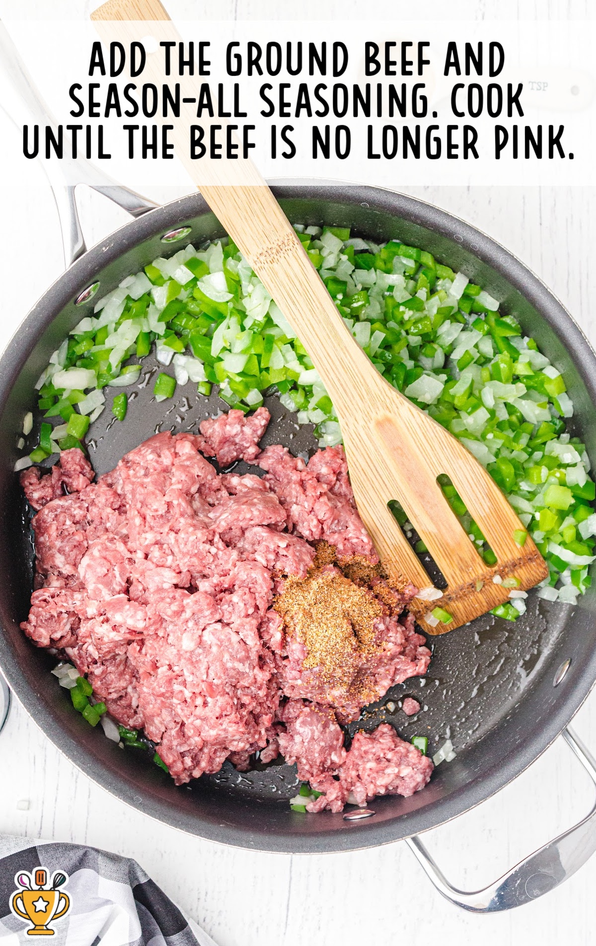 Ground beef, green bell pepper, and chopped onion in a skillet with seasoning being stirred using a wooden spatula.