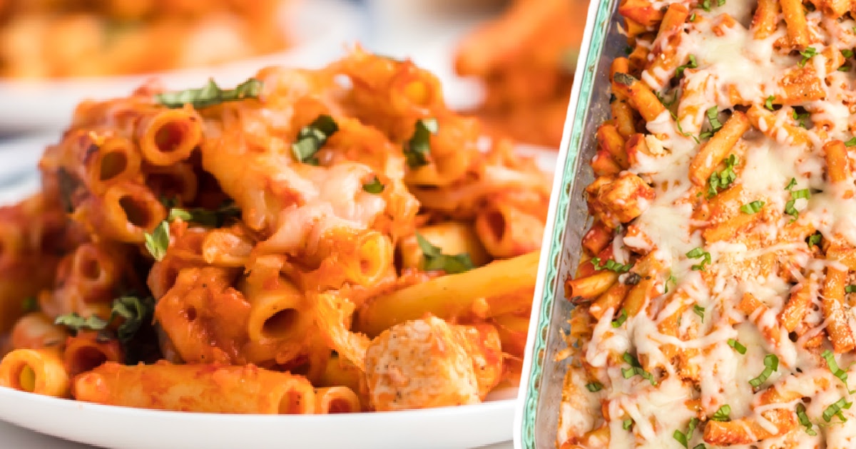 Vertical image of baked ziti with chicken on a white plate, loaded with melted mozzarella cheese and garnished with chopped basil.