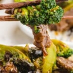 Close-up of chopsticks holding beef and broccoli, text overlay “Easy Beef and Broccoli Make at Home in 30 Minutes”