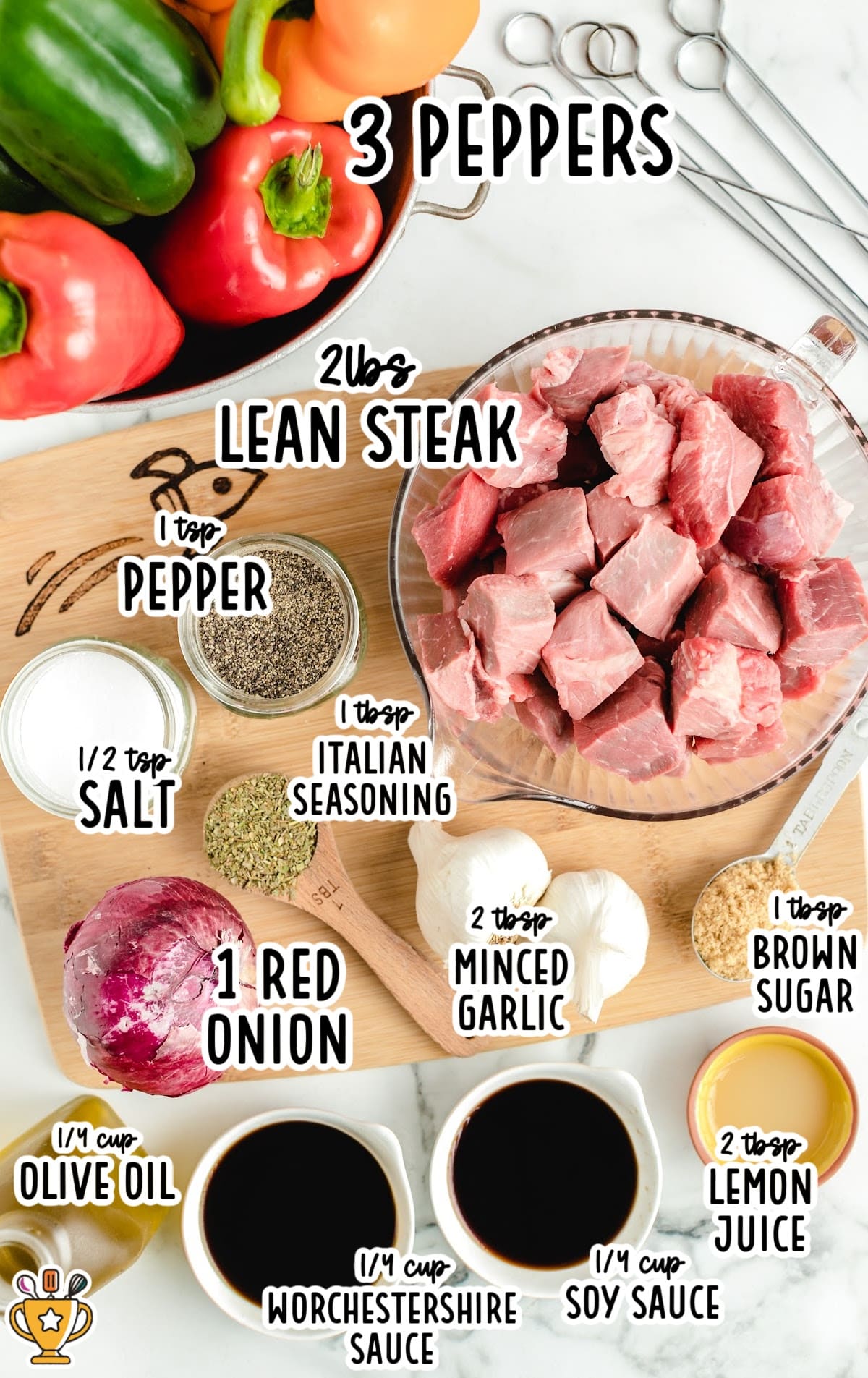Flat lay of ingredients including steak, bell peppers, onion, garlic, spices, and sauces needed to make beef kabobs.