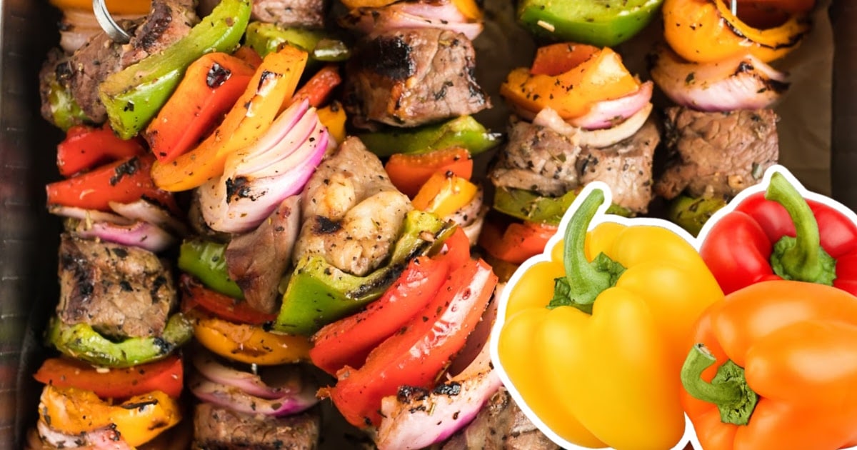 Zoomed-in shot of grilled beef kabobs packed with red, green, and orange bell peppers, onions, and char-grilled beef cubes.