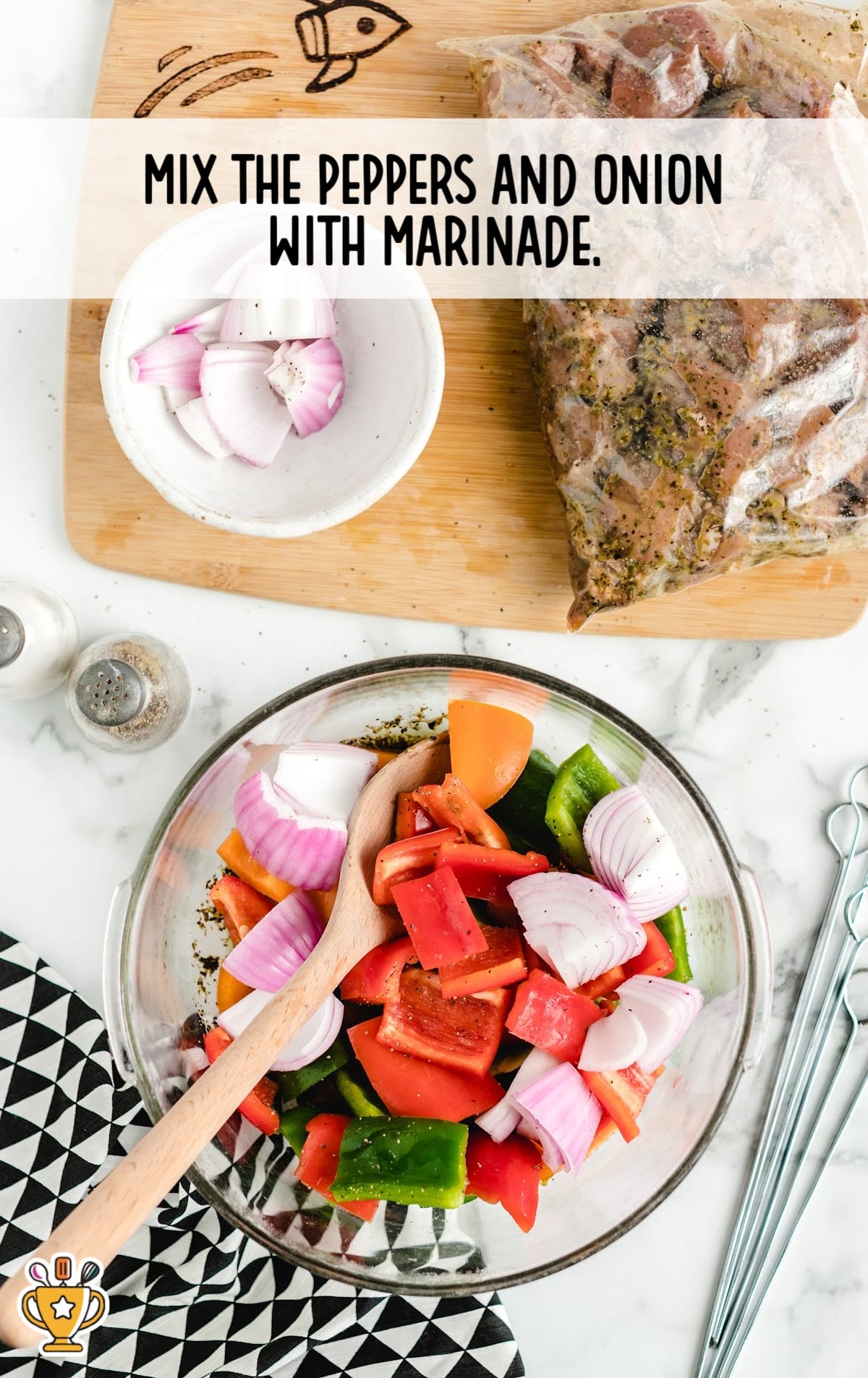 Bowl of chopped red, orange, and green peppers mixed with red onion and marinade, with the beef marinating nearby.