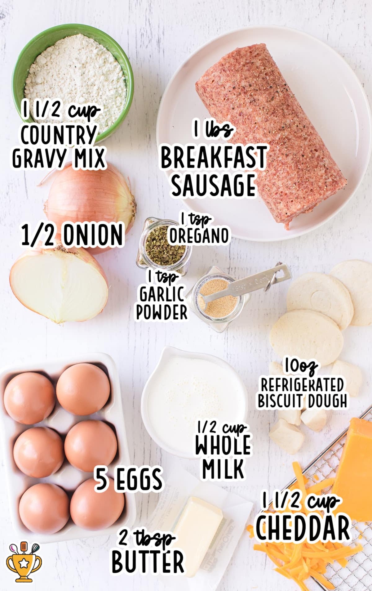 Flat lay of ingredients for biscuits and gravy casserole including eggs, sausage, cheddar, milk, biscuit dough, and gravy mix.