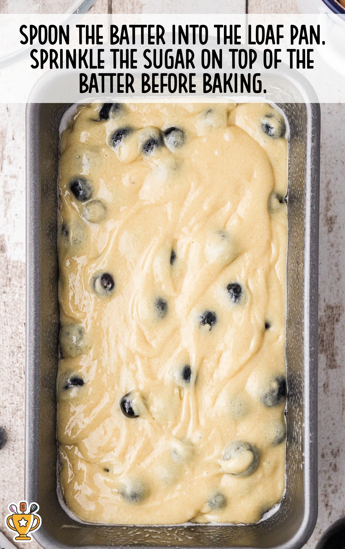 Batter with blueberries spooned into a loaf pan, with sugar sprinkled on top before baking, shown with step text
