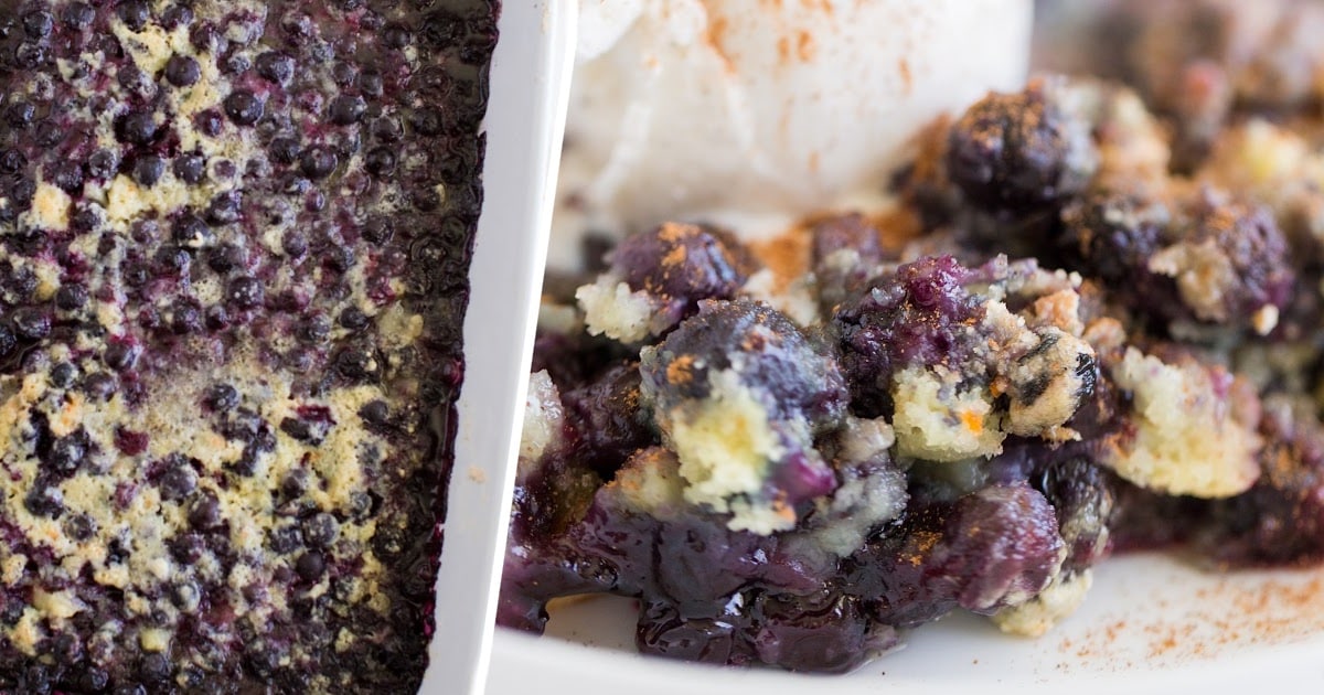Fresh blueberries in a white bowl beside a plate filled with warm blueberry cobbler and a scoop of ice cream.