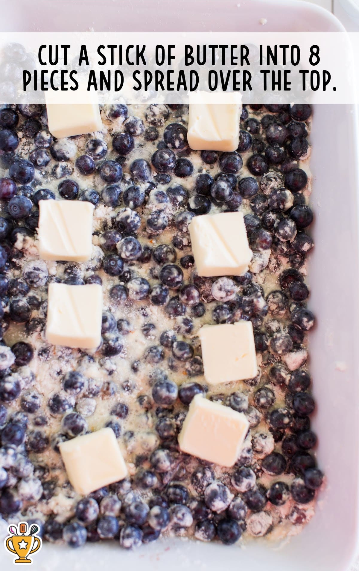 Slices of butter spread across the top of a blueberry and cake mix mixture inside a baking dish. Text overlay reads "Cut a stick of butter into 8 pieces and spread over the top."