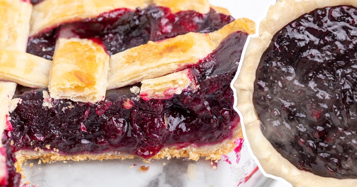 Zoomed-in view of a blueberry pie with a bite taken out, showing the thick juicy filling and buttery golden crust.