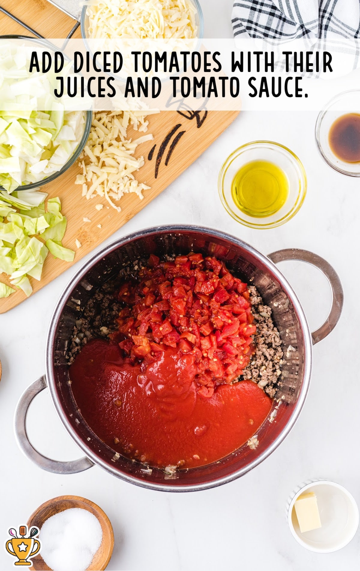 Diced tomatoes with their juices and tomato sauce added on top of the seasoned ground beef mixture in a pot.