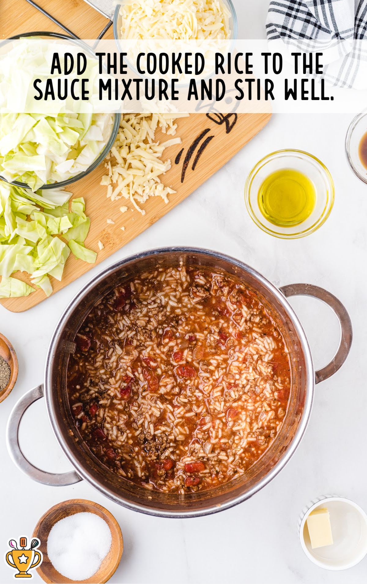 Cooked rice mixed into the tomato and ground beef sauce, creating a thick filling mixture for the casserole.