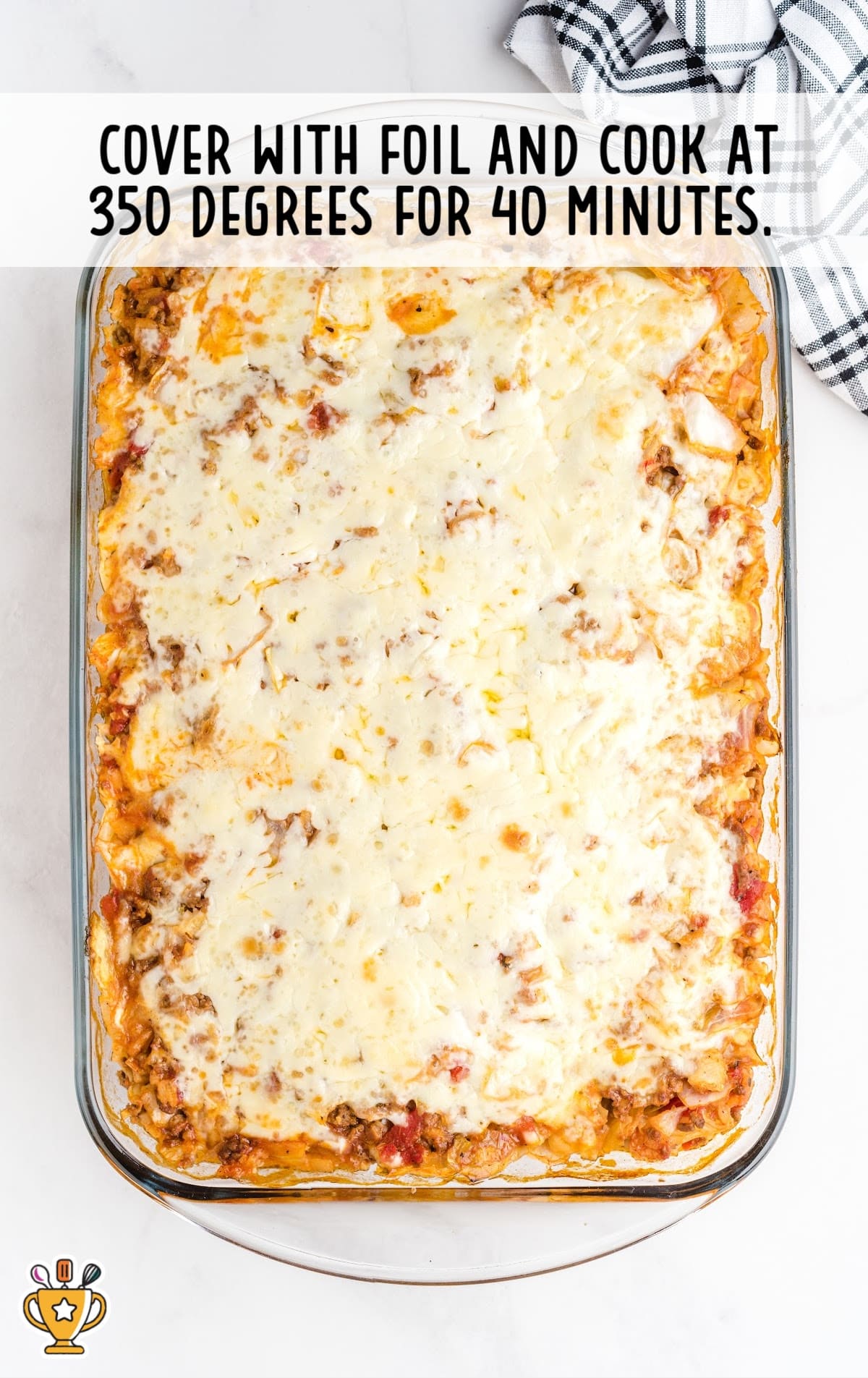 Fully baked cabbage roll casserole in a glass baking dish with golden melted cheese on top after cooking for 40 minutes.