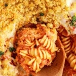 Vertical image with the phrase “Classic Chicken Parmesan Casserole Recipe” above a close-up of a wooden spoon lifting a cheesy, golden-topped serving from the casserole dish.