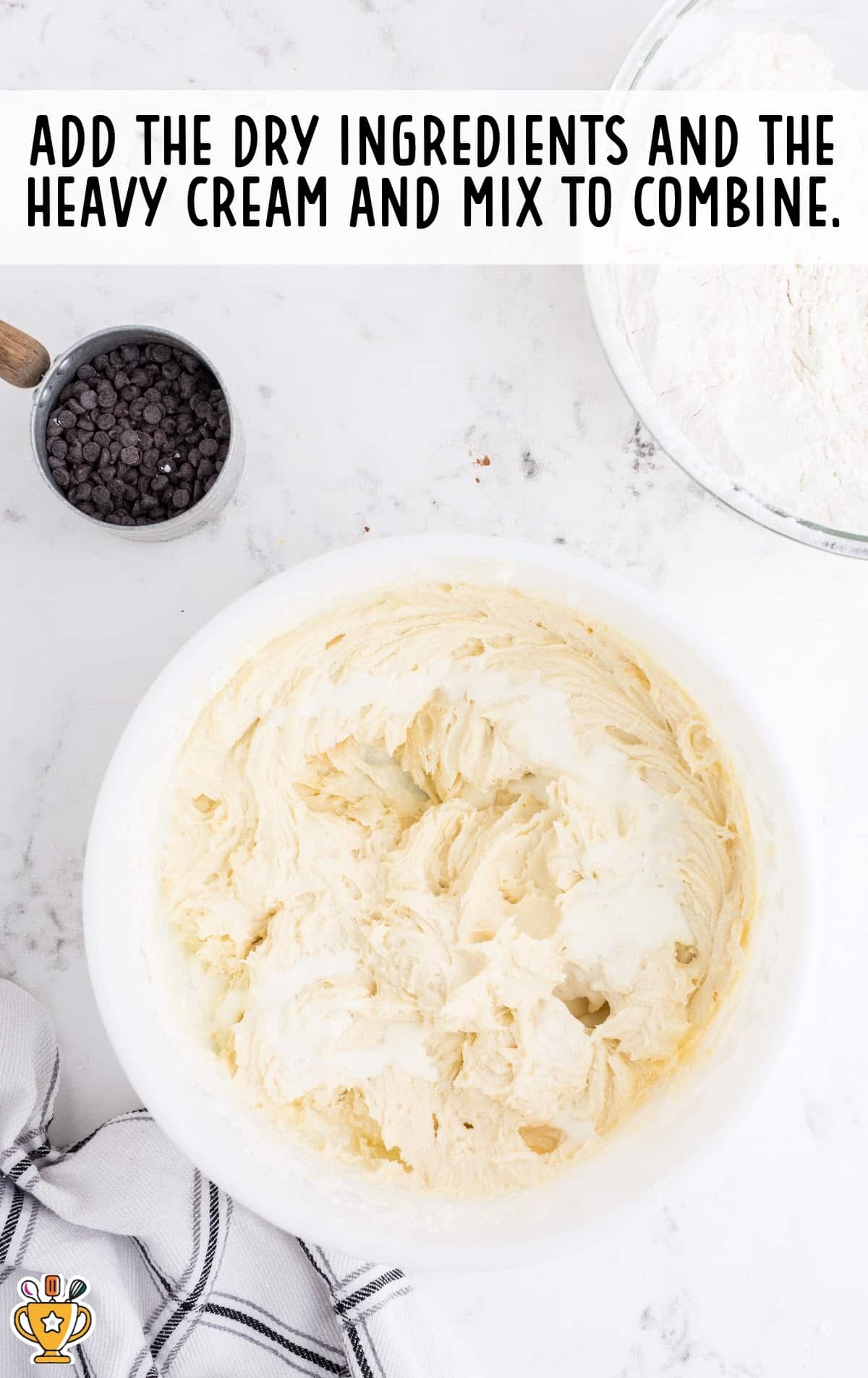 Creamy cheesecake cookie dough with heavy cream added, ready to mix with the dry ingredients.