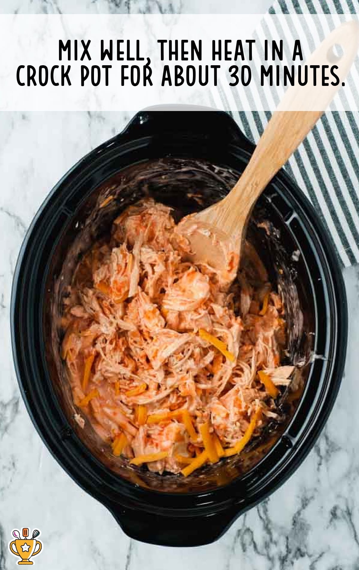 Mixed buffalo chicken dip heating in a crockpot with visible shreds of chicken, cheese, and creamy orange sauce.