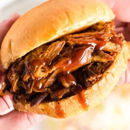 Recipe card showing a juicy pulled pork sandwich with BBQ sauce on a bun, styled with a collage of ingredients and final dish.