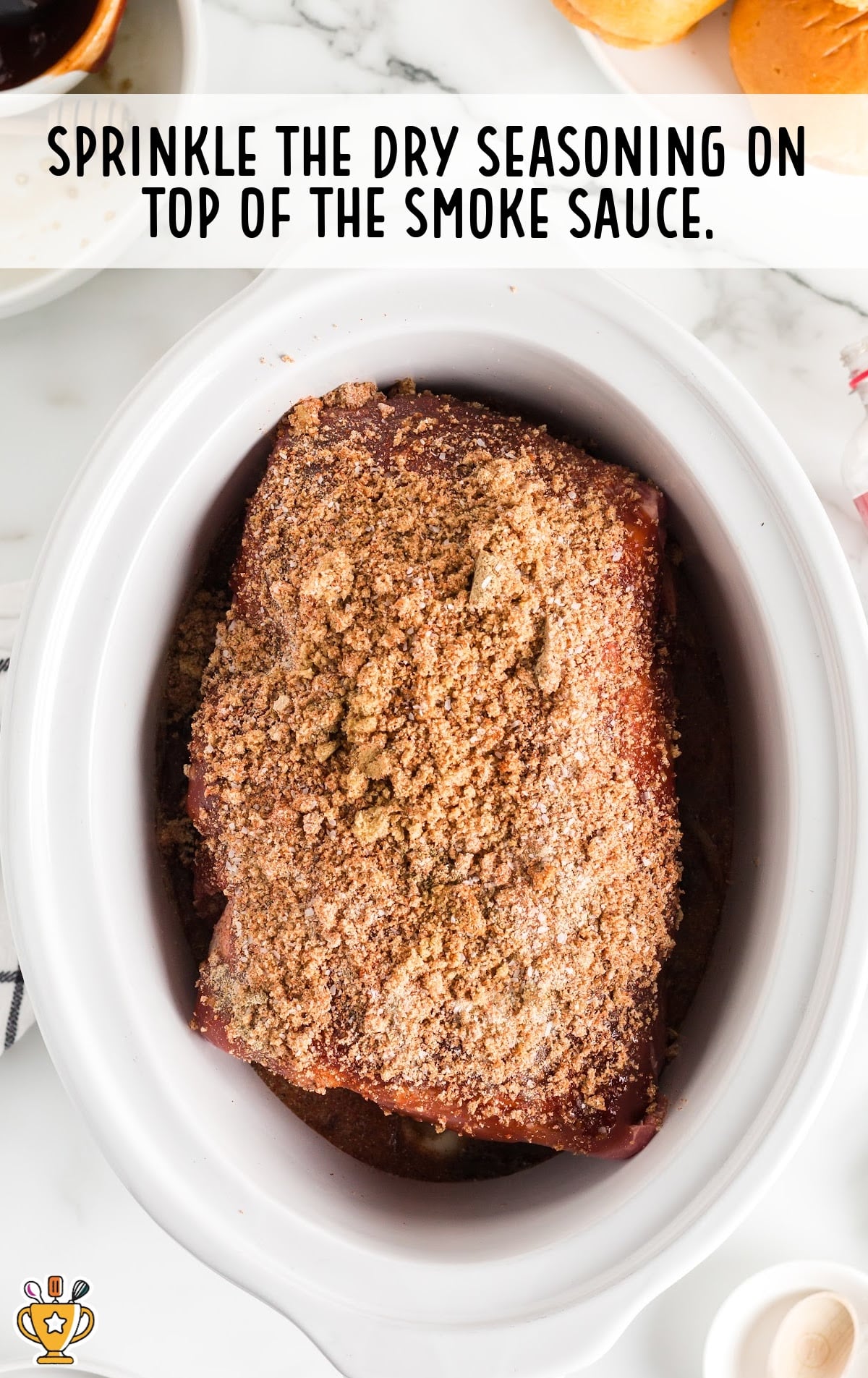 Pork in the crockpot covered in dry seasoning rub, showing the step before slow cooking begins.