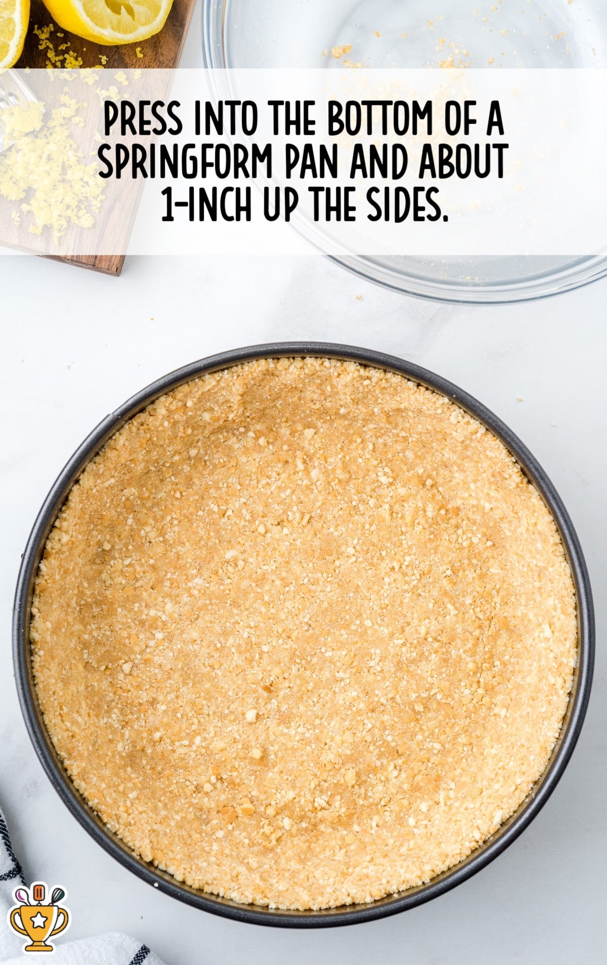 Crumb mixture pressed evenly into the bottom and sides of a springform pan, ready to be baked as a cheesecake crust.