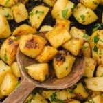 Fried potato chunks in a cast iron skillet with parsley, highlighted with the text "the best fried potatoes" and "perfectly seasoned" at the bottom.