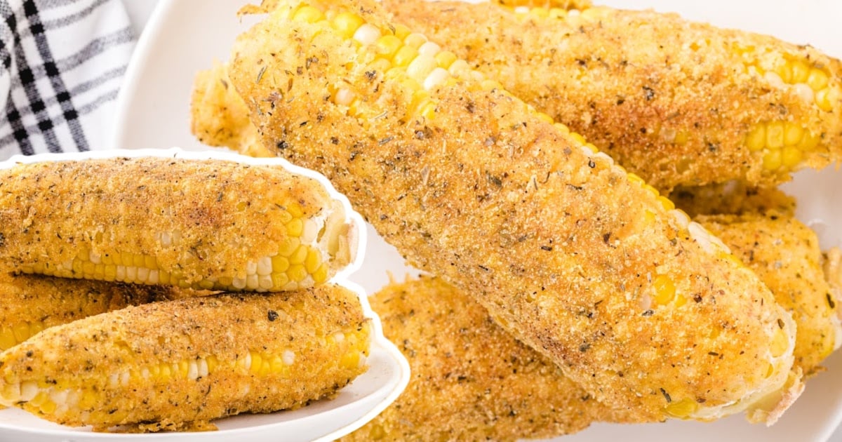 Zoomed-in photo of several fried corn on the cob showing a golden crispy batter and seasoning details.