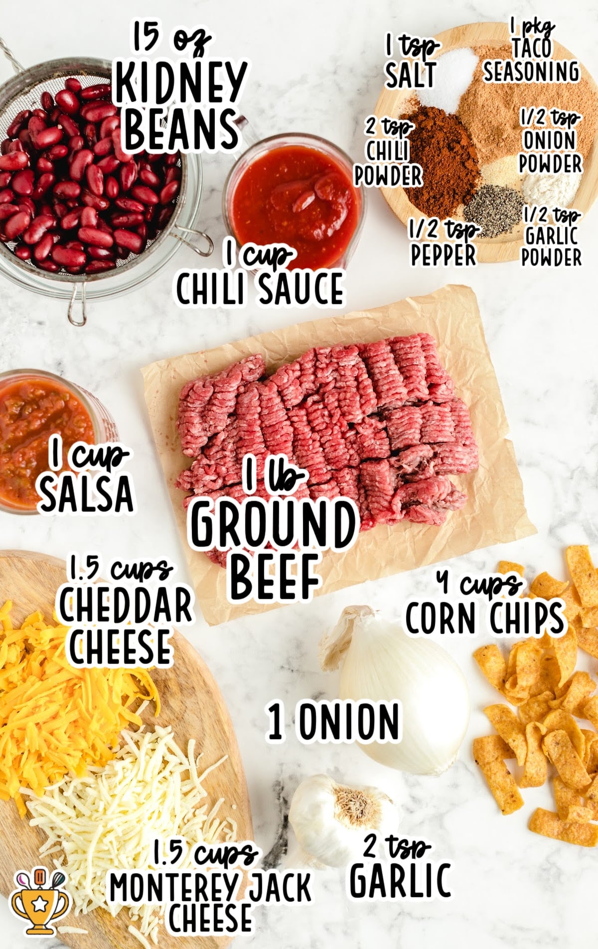 A flat lay of all Frito pie ingredients including ground beef, kidney beans, cheese, seasonings, onion, garlic, salsa, and chili sauce arranged neatly.