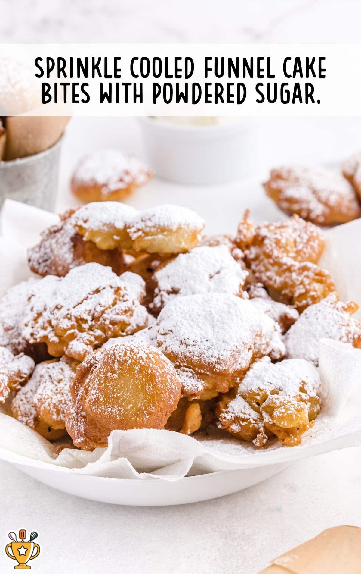 A bowl of crispy funnel cake bites generously dusted with powdered sugar, ready to serve.
