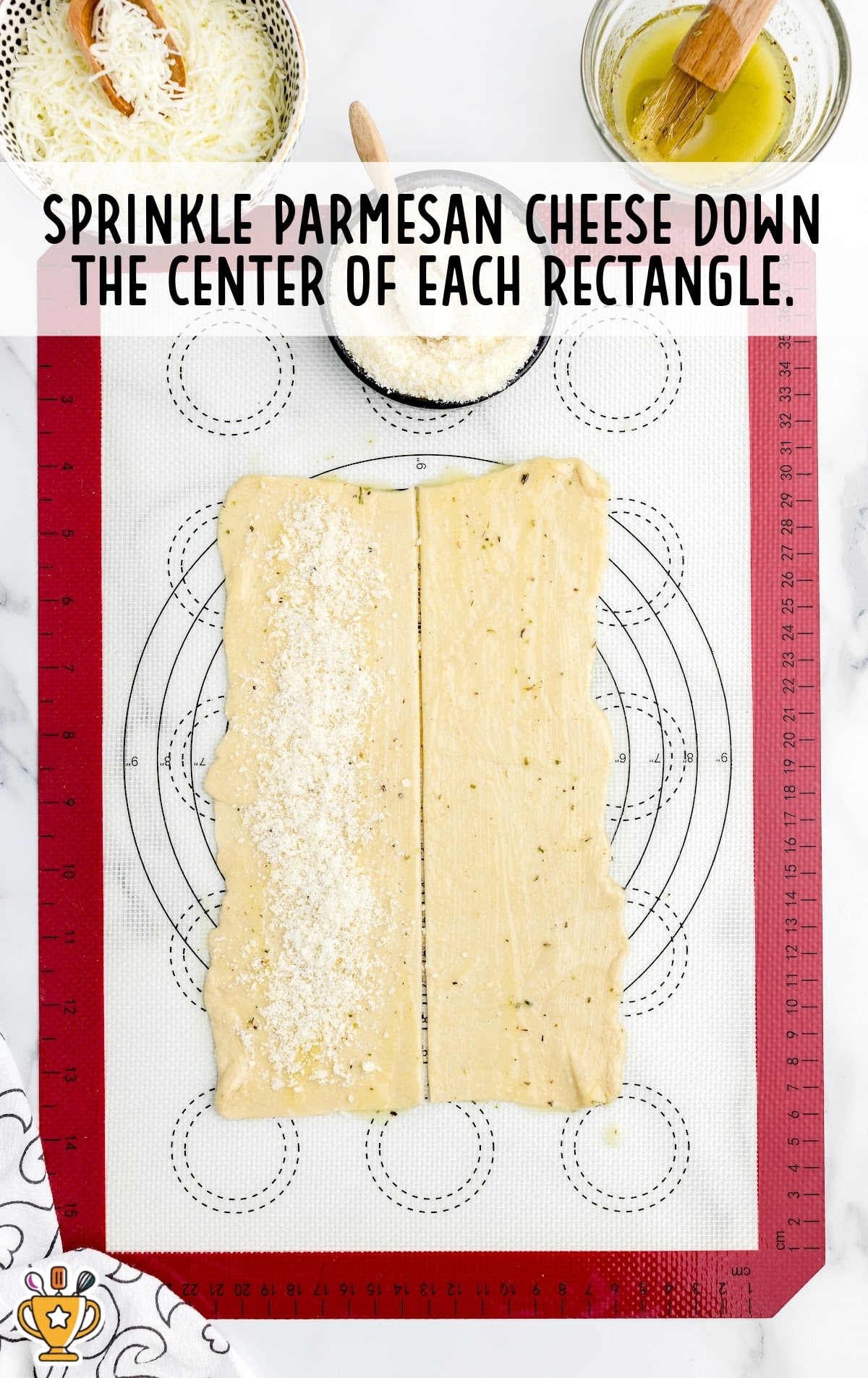 Each rectangle of crescent dough sprinkled with parmesan cheese down the center, ready to be folded.